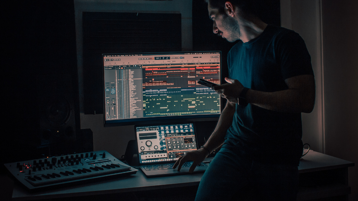 dark music production studio with logic pro daw open on the screen